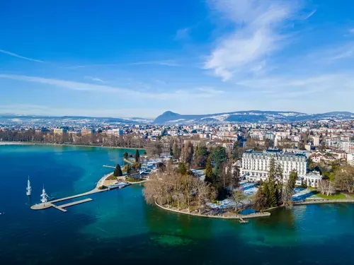 Vue aérienne d'Annecy et de son lac en hiver, avec les montagnes enneigées en arrière-plan