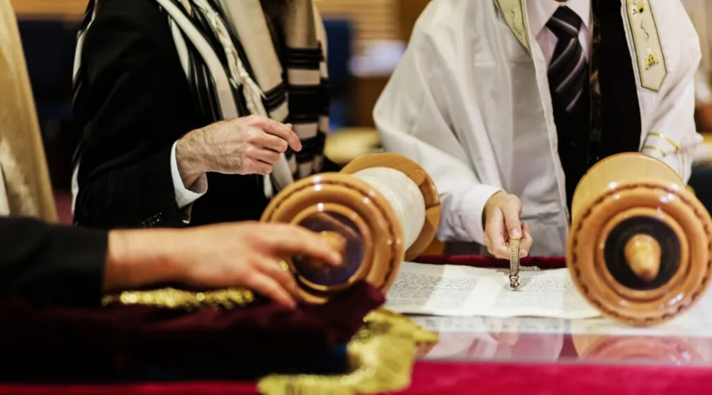 Un garçon suit la lecture du Sefer Torah avec le yad le jour de sa Bar Mitzvah