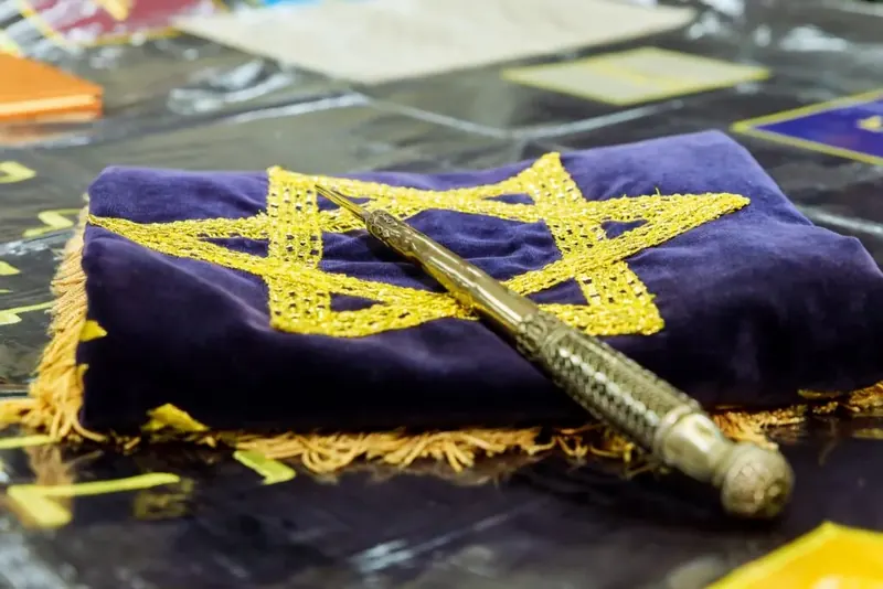 Yad en argent posé sur un manteau de Torah brodé d'une étoile de David