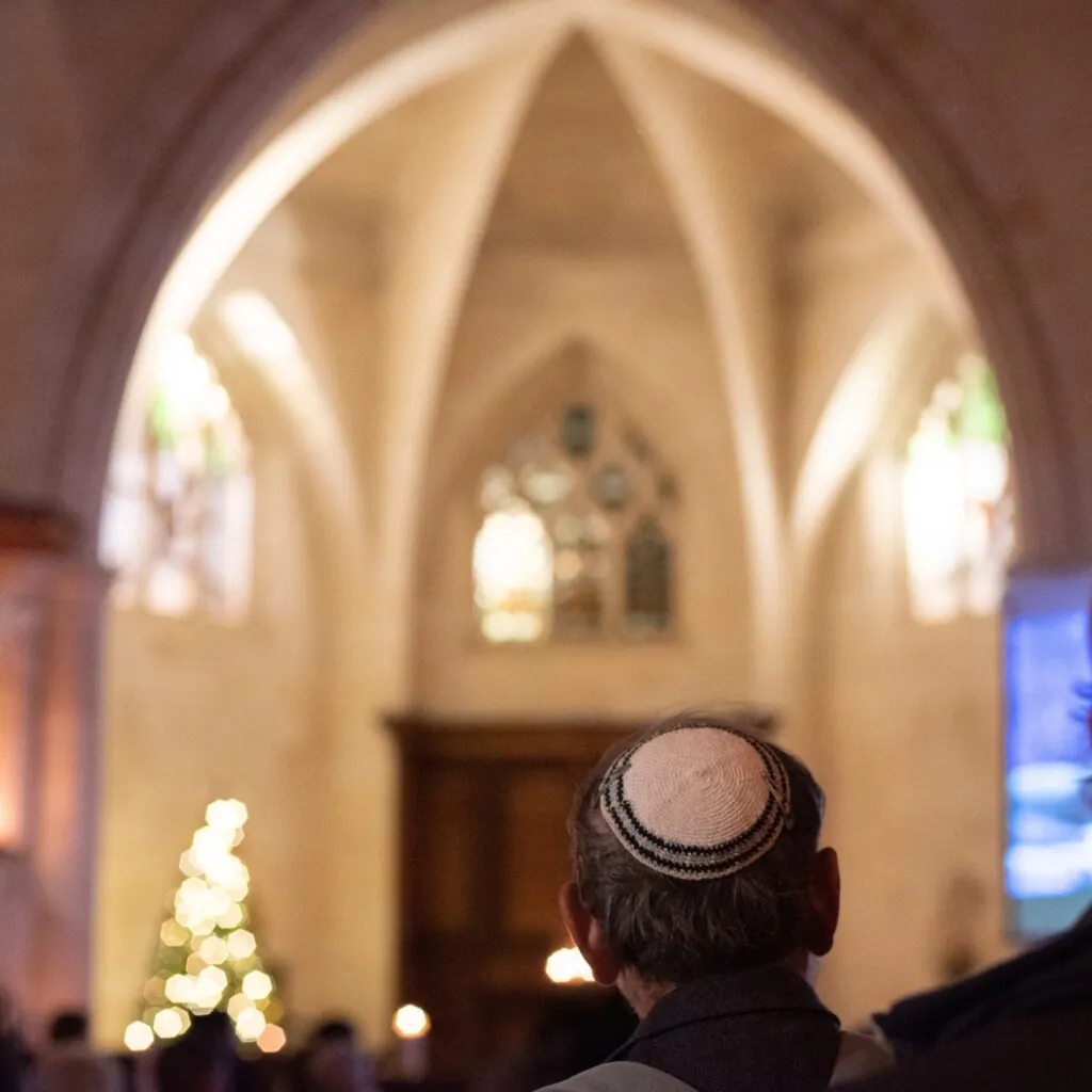 Man with a white kippah in a Synagogue with a blurry background and bokeh effect