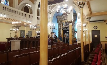 Salle de prière d’une synagogue avec l’arche sainte ornée et les bancs des fidèles
