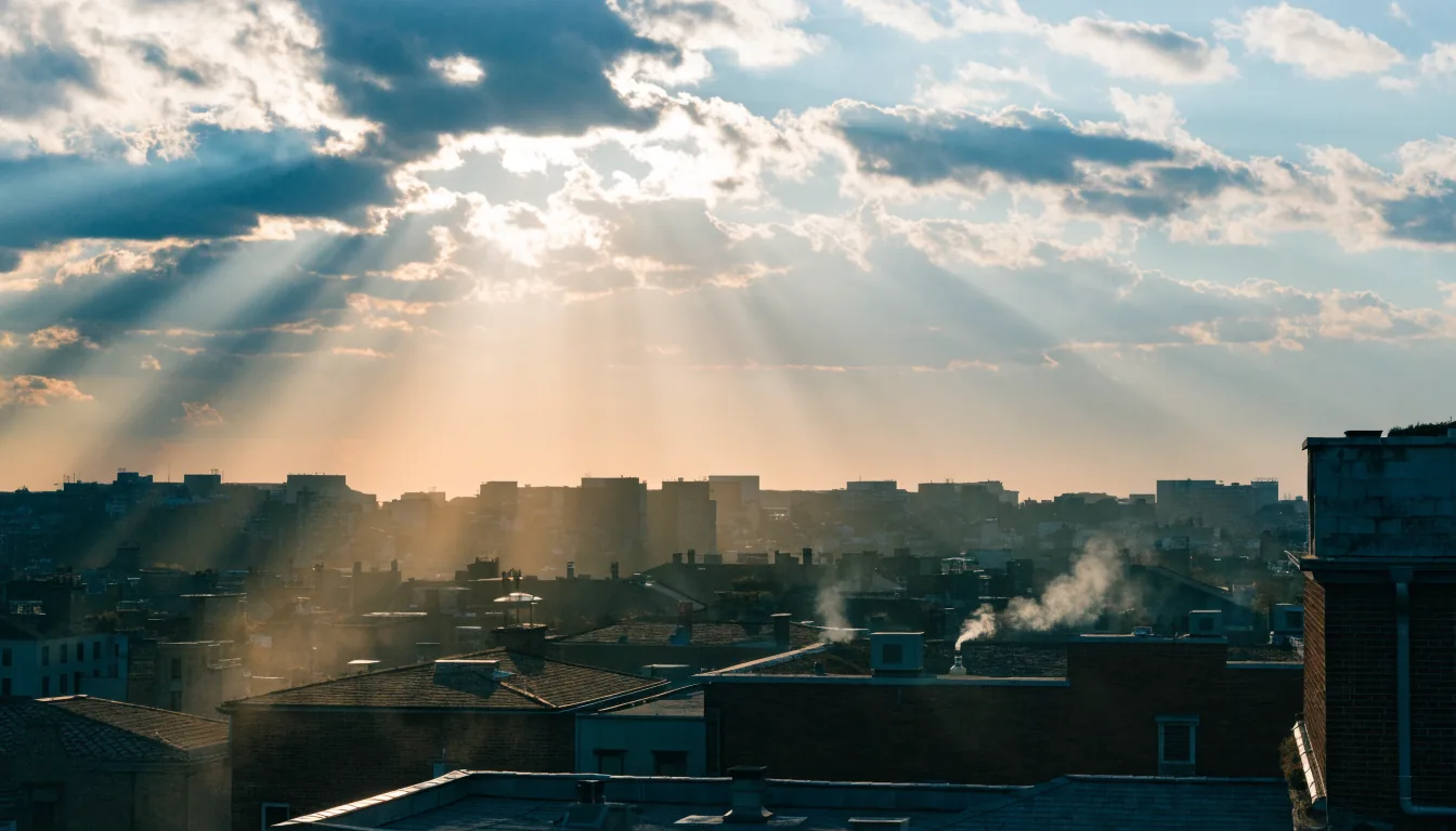 Ciel de l'aube traversé de rayons de lumière au-dessus des toits