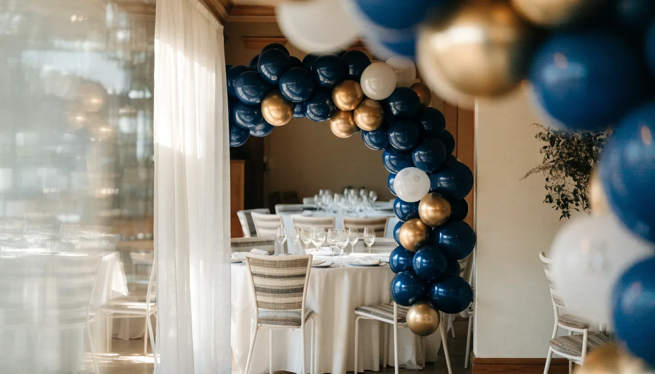 Arche de ballons bleu marine, blancs et or à l'entrée d'une salle de réception