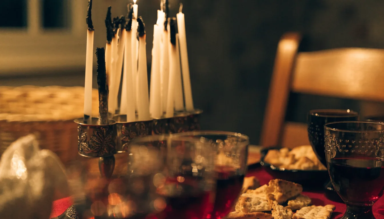 Table du Seder en fin de soirée, bougies et coupes de vin, ambiance chaleureuse