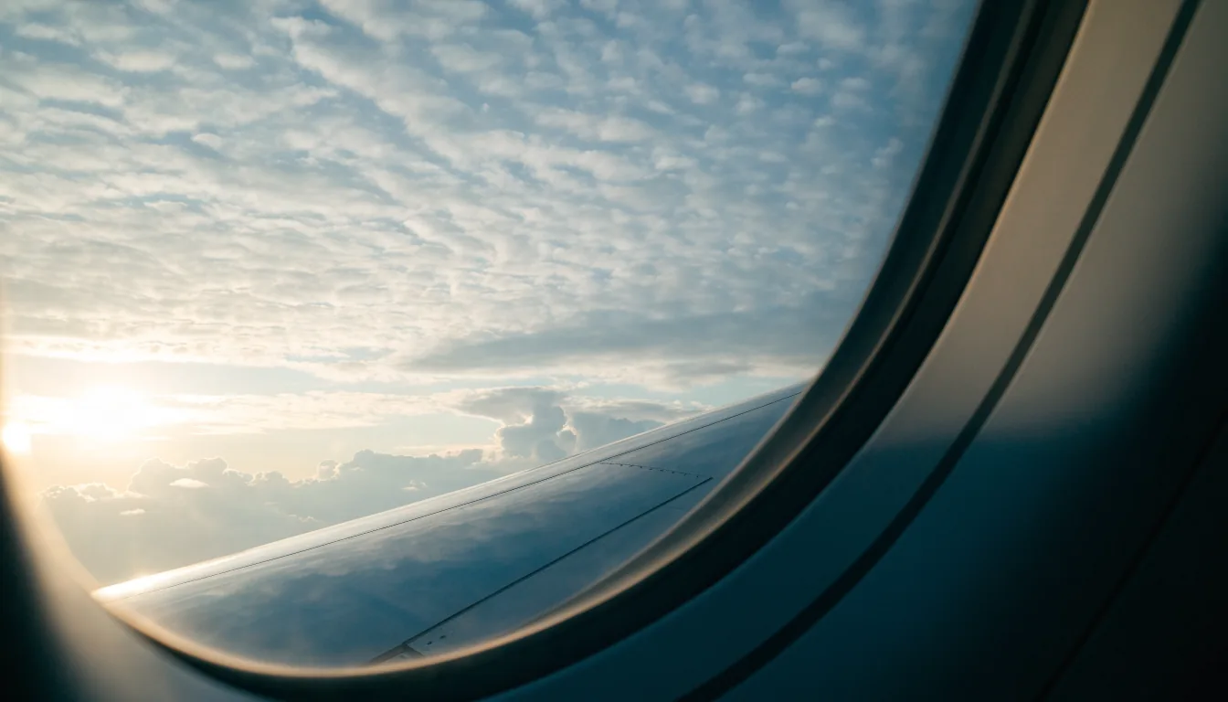 Vue sur les nuages depuis le hublot d'un avion au lever du soleil